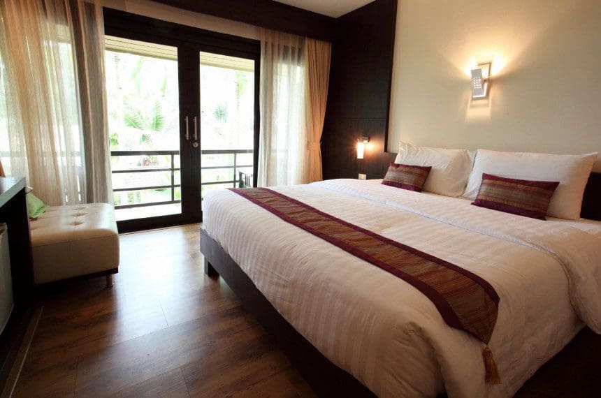 A bedroom with a large bed and sliding glass doors.