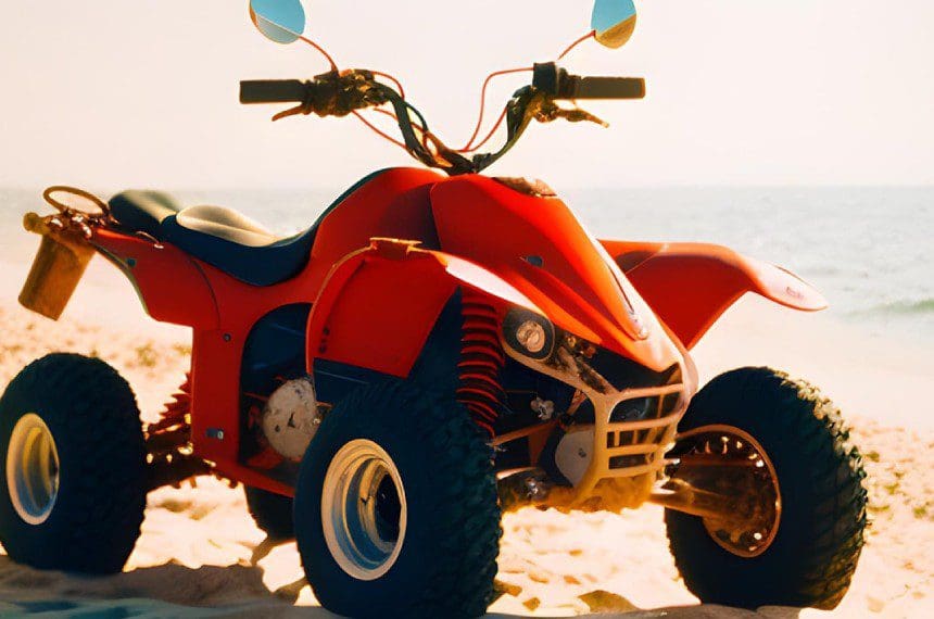 A red four wheeler parked on the beach.